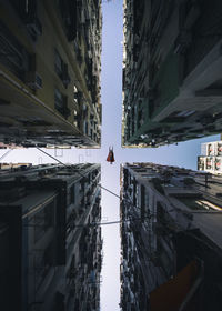 Directly below shot of superman flying amidst buildings in city