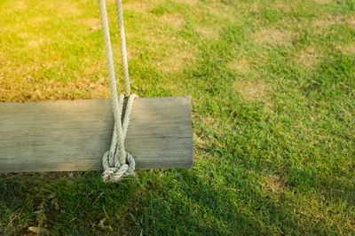 High angle view of wooden swing over grass