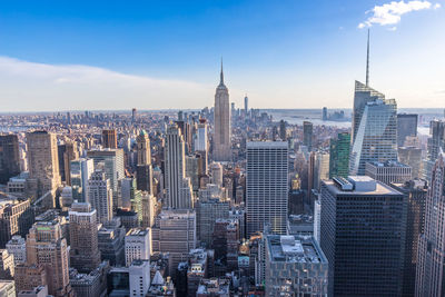 Aerial view of buildings in city against cloudy sky