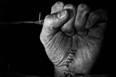 Close-up of human hand against black background