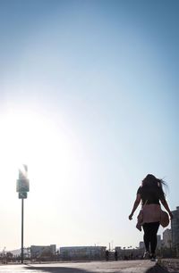 Rear view of woman standing against sky