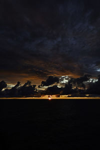 Scenic view of sea against dramatic sky during sunset
