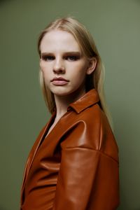 Portrait of young woman against wall