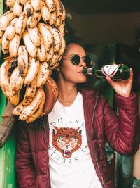 Midsection of woman wearing sunglasses standing outdoors