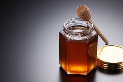 Close-up of honey in jar on gray background