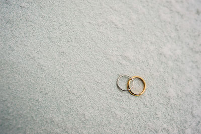 High angle view of wedding rings on beach