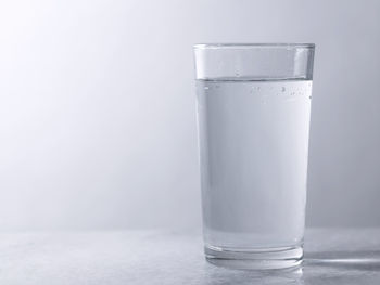 Glass of clear water on the gray background