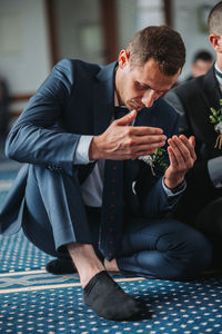 Young man sitting in a dress