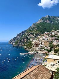 Scenic view of town by sea against sky