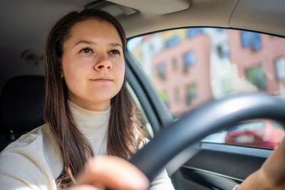 Portrait of young woman sitting in car