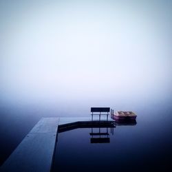 Pier over lake during foggy weather