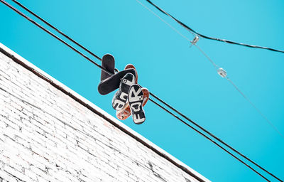 Low angle view of cable hanging against clear sky