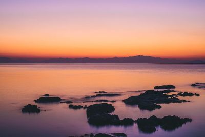 Scenic view of sea against romantic sky at sunset