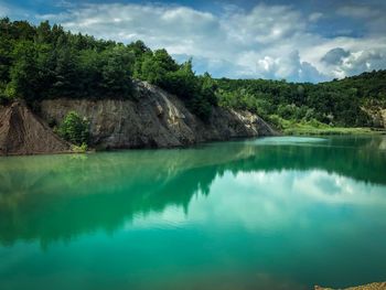 Scenic view of lake by mountains against sky