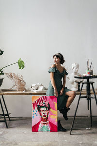 Female artist sitting painting and bust at art studio