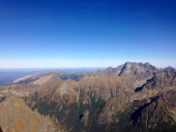 Scenic view of mountains against blue sky