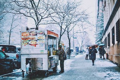 People on snow covered city in winter