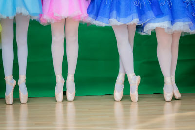 Low section of people standing on wooden floor