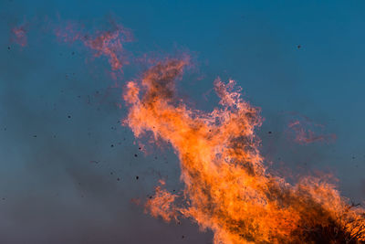 Low angle view of fire against blue sky