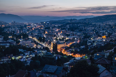 High angle view of illuminated city against sky at sunset