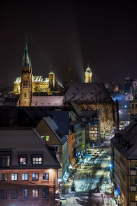 Illuminated buildings against sky at night