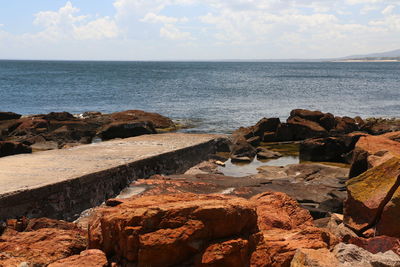 Rock formations by sea against sky