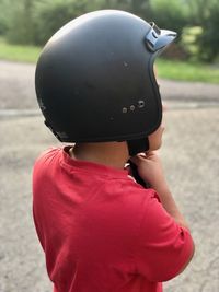 Rear view of boy holding hat