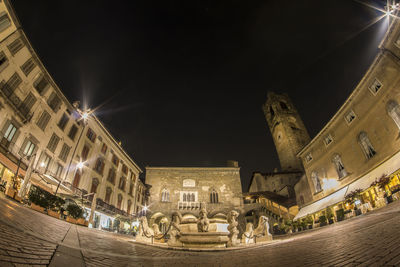 Low angle view of buildings against sky at night