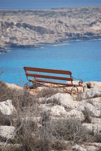 Empty bench on cliff in front of sea