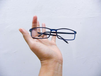 Cropped hand holding eyeglasses