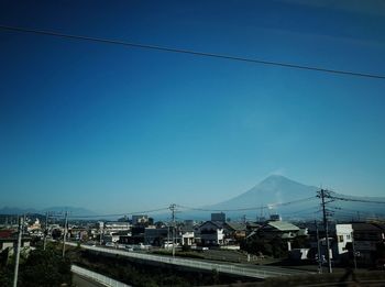 Panoramic view of city against clear blue sky