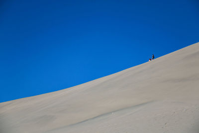 Scenic view of desert against blue sky