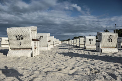 Lounges on sand against sky