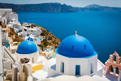 Panoramic view of sea and buildings against blue sky