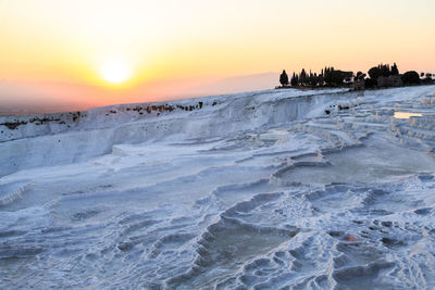 Scenic view of frozen sea against sky during sunset