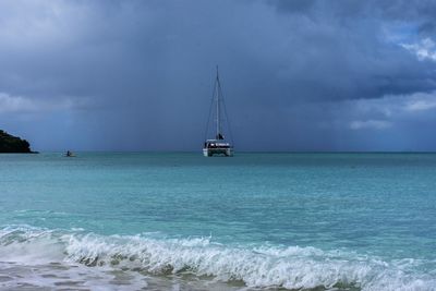 Sailboat sailing on sea against sky