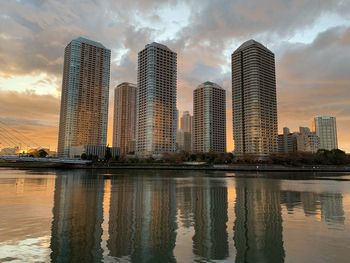 Reflection of buildings in city against sky