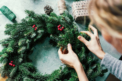 High angle view of woman making wreath on table