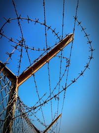 Low angle view of barbed wire against clear sky