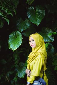 Portrait of smiling young woman with yellow leaves