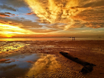 Scenic view of beach against dramatic sky