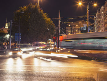 Blurred motion of cable car on road in city at night