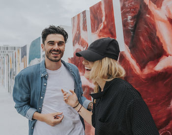 Young couple standing against the wall