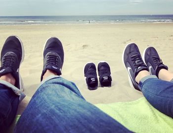 Low section of people standing on beach