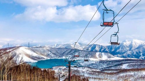 Overhead cable car over snowcapped mountains against sky