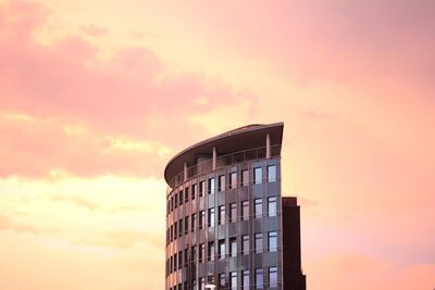 Low angle view of modern building against sky at sunset