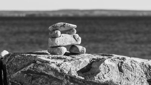 Close-up of stone stack on rock against sea