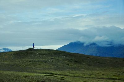 Man walking on mountain against sky
