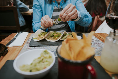 Midsection of woman having food in restaurant