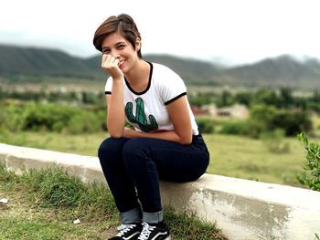 Portrait of young woman sitting on field